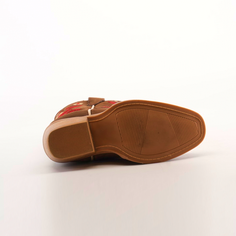 A close-up of a brown leather boot’s sole with a wooden heel, mirroring the handcrafted style of Mia Copper Suede - Snip Toe boots. Red floral embroidery adorns the upper edge, and textured sections on the premium leather sole enhance grip. The background is plain white.