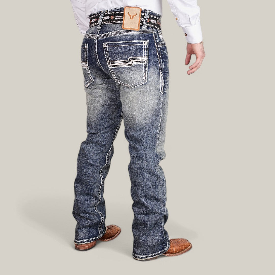 A person is dressed in Western Blue Straight Fit Embroidered Jeans - W431, featuring detailed back pocket stitching. The look is completed with a white shirt, a patterned belt, and brown shoes against a plain light gray background.