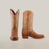 A pair of Sierra Fawn - Wide Cutter Toe cowboy boots made from premium cowhide leather, featuring intricate stitching and pull straps, is displayed on a white background; one boot faces forward while the other shows the side profile with heel and design details.