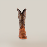 A Fresno Tan - Wide Cutter Toe boot made from premium cowhide leather, featuring intricate stitching and a pointed toe, stands against a plain white background. It has a tall shaft with decorative lighter patterns, capturing the cowboy lifestyle essence