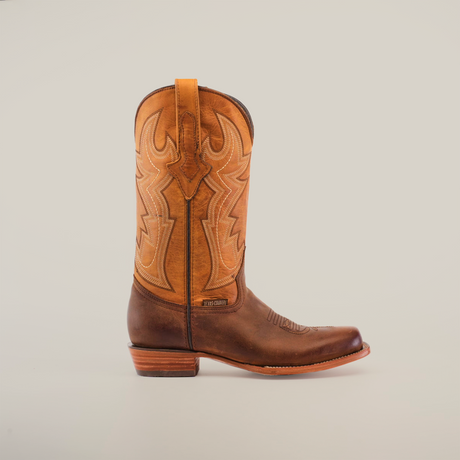 The Azkar Tan - Wide Cutter Toe cowboy boot, made from luxurious cowhide leather, features intricate upper stitching. It has a low, slightly worn heel and smooth toe, showcased side profile against a plain white backdrop for a captivating look.