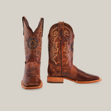 The Fresno Shedron Star - Square Toe boots are made of premium cowhide featuring intricate light-colored stitching and an emblem. One boot faces forward, while the other shows the side profile against a plain white background.