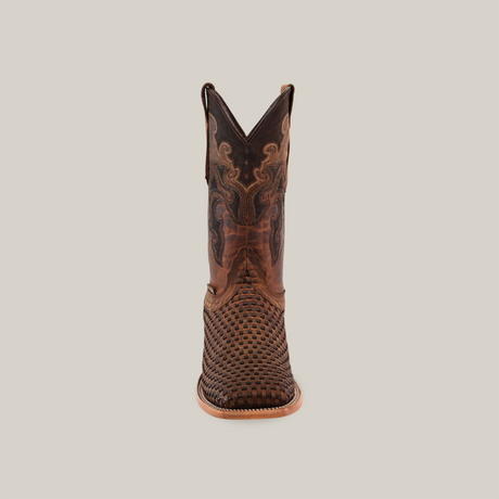 A brown cowboy boot, made of premium cowhide, is set against a white background. It features intricate stitching on the shaft and the Texas Basket Weave Matte Brown pattern on its square toe, with a light brown sole and heel.