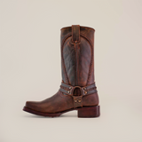 The Azkar Tan features a single handcrafted brown leather cowboy boot with intricate stitching and an ankle harness detail, offering a square toe and low heel. It comes with a slip-resistant sole, showcased against a plain white background.