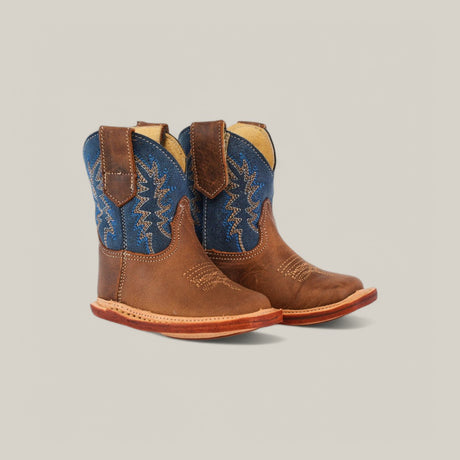 The Max - Honey Blue Shaft boots feature brown genuine leather square toes and vibrant red soles. The blue shafts, adorned with white embroidery, create a charming western look against a light gray background.