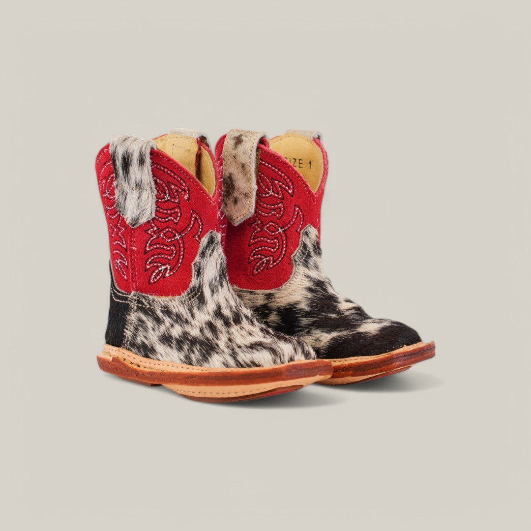 These Cowhide Hair Baby Boots boast a red suede shaft, black-and-white cowhide patterns, and a square toe design. Finished with brown leather soles and pull tabs, theyre a standout addition to any little ones collection. Product Name: Cowhide Hair - Red Suede Shaft - Square Toe.