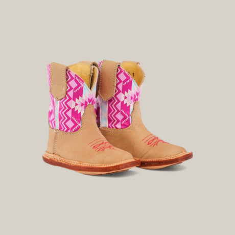 The Holly boots feature a square toe and tan leather foot, accented by a natural pink Aztec pattern in pink, white, and purple on the shaft. Red stitching adds flair, while their sturdy brown sole ensures durability.