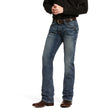 A person wearing a black long-sleeve shirt and M5 Slim Stretch Adkins Stackable Straight Leg Jean in lennox, accented with a brown belt and cowboy boots, stands against a plain white background with their hands clasped in front.