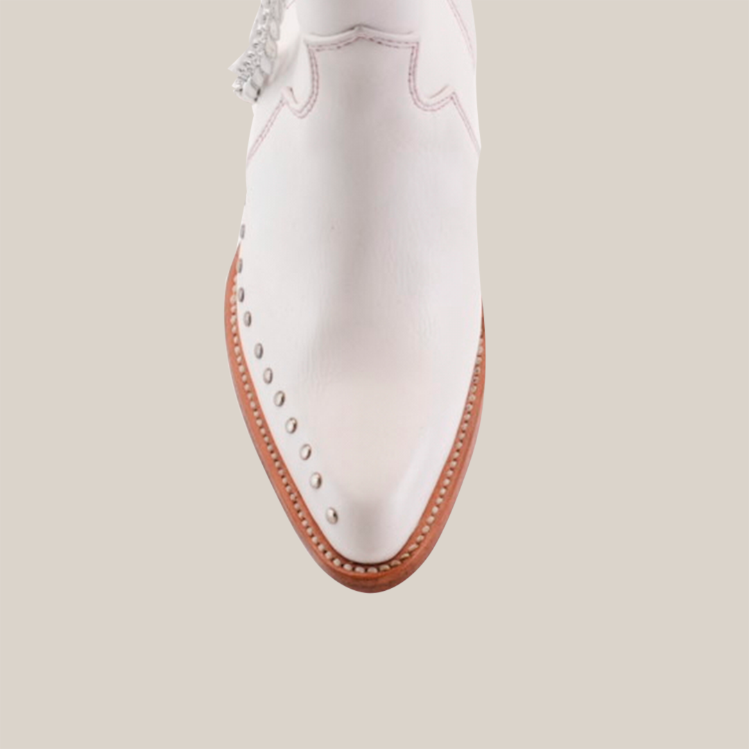 A close-up image of the Milan Chains Bootie Frost White - J Toe highlights its premium leather and decorative studs, with a brown sole and silver ankle chain from the exclusive Platinum Collection against a plain white background to emphasize its exquisite design.