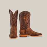 An Exotic Python - Tamarindo boot set, showcasing artisan craftsmanship, adorns a light backdrop. The left boot presents a front view with detailed stitching and texture, while the right boot in profile highlights its intricate design and heel.