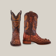 The Exotic American Alligator Head boots in brown feature intricate patterns and textures. One handmade boot stands upright, displaying the front design, while the other reveals a stylish square toe from the side.