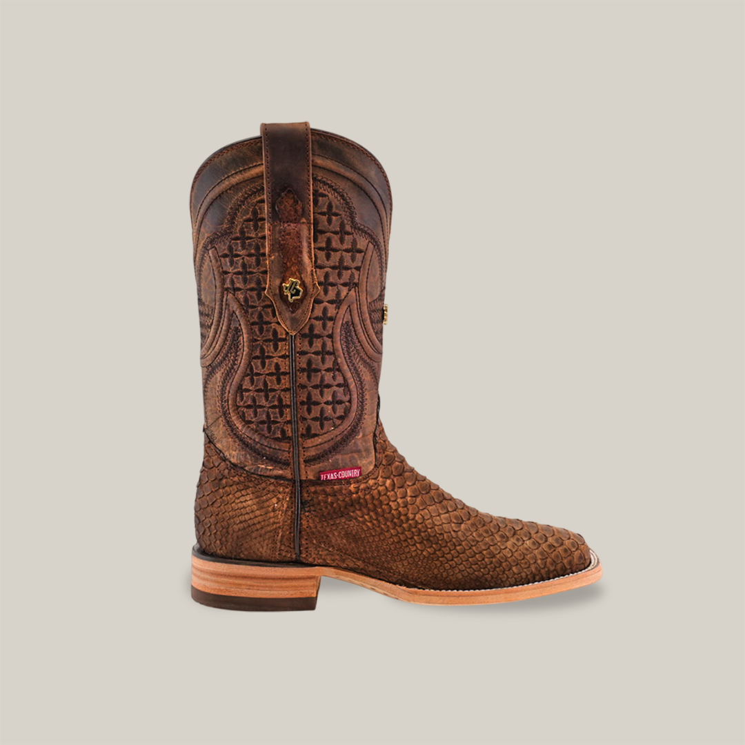 Exotic Python - Tamarindo - Square Toe boot, adorned with intricate textured patterns and stitching, features a flat wooden heel and branded tag on the side, highlighting artisan craftsmanship in its design against a light gray background.