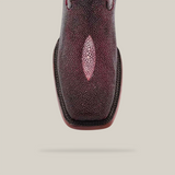 An overhead shot showcases the Exotic Stingray in Wine, crafted from luxurious stingray leather. This boot features a Rodeo toe with a striking light patch center. The textured surface stands out against the plain, neutral background.