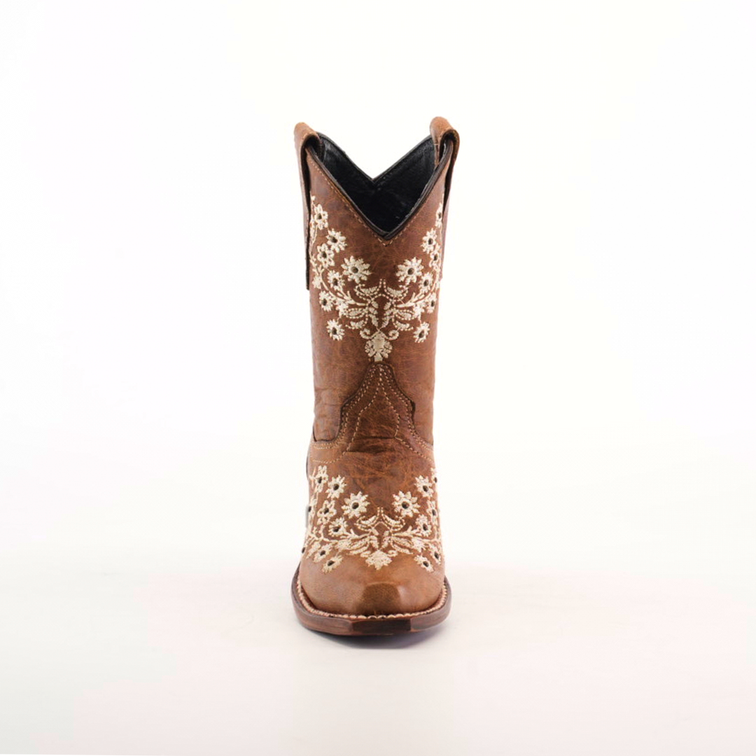 The Abril Studs Orix Snip Toe boot, set against a white background, showcases intricate white floral embroidery on the front and sides of a single brown cowboy boot with a classic snip toe design.