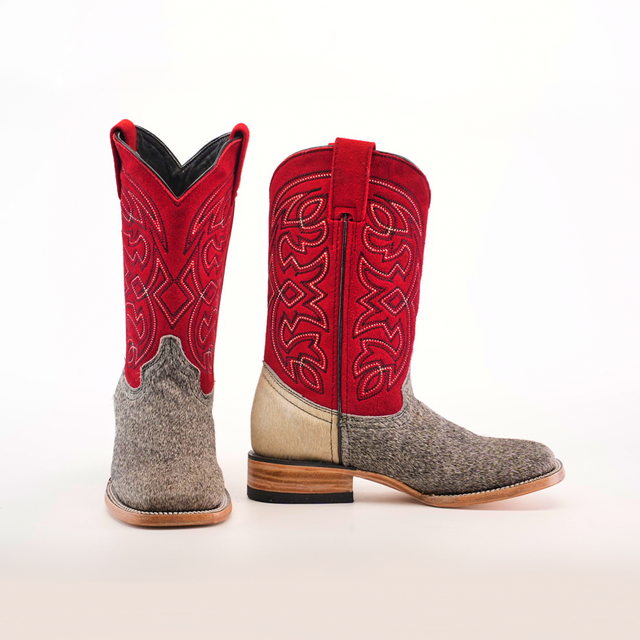 The Cowhide Hair Pinto Square Toe boots feature red intricately stitched shafts, gray textured hair-on-hide leather on the foot and heel, cowhide material, wooden soles, and a square toe. They are displayed upright with one facing forward and the other to the side.