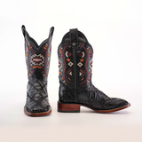 A pair of Exotic American Alligator Patchwork Black Square Toe cowboy boots features intricate multicolored geometric patterns on the shafts, mimicking exotic leather textures. The boots have a wooden sole and a pointed toe, displayed upright on a white background.