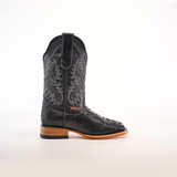 The Caiman Hornback Print Black Square Toe cowboy boot, shown sideways on a white background, features intricate stitched patterns and a caiman hornback print. Made from premium materials, its square toe and light brown sole contrast appealingly with the dark upper.