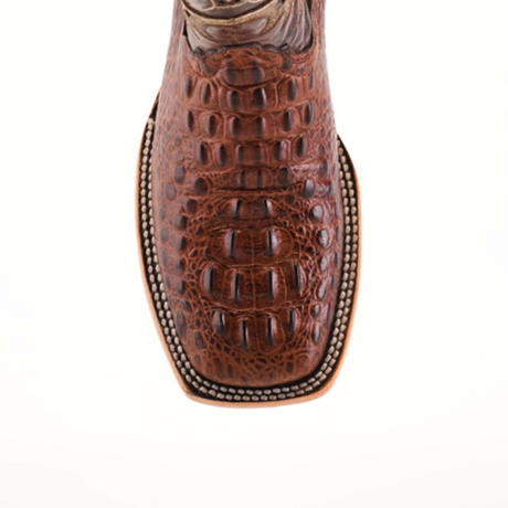 Close-up of the toe of a Caiman Hornback Print Chocolate Square Toe cowboy boot, highlighting its luxurious reptile-like pattern and intricate stitching detail on a light background.