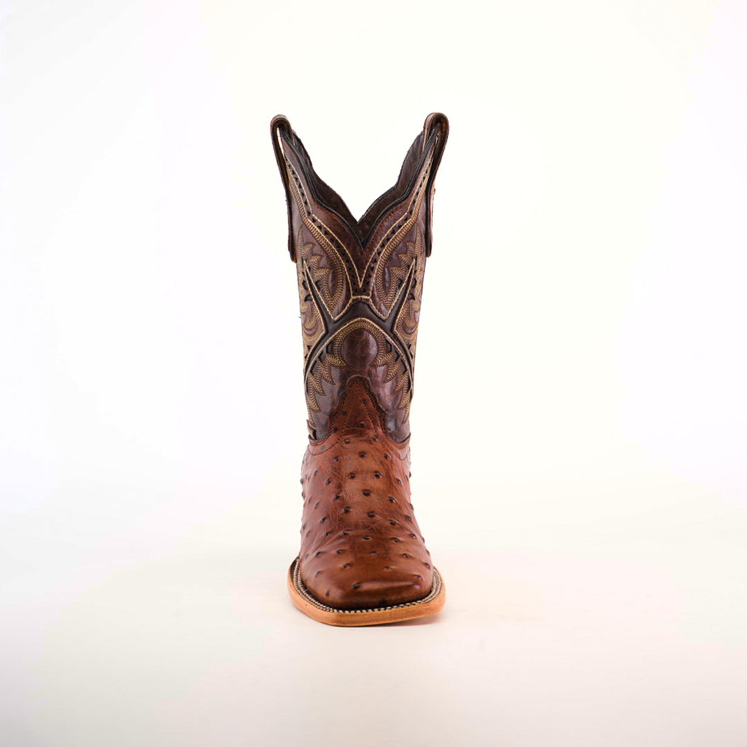 A single chocolate cowboy boot, made from premium materials, stands upright against a plain white background. It features intricate stitching and patterns with a distinctive Karoo Ostrich Print, square toe, and tall shaft.