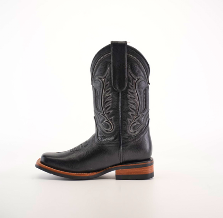 The Barcelona Black Slip Resistant Sole Rodeo Toe is a premium leather cowboy boot with intricate stitching, featuring a pointed rodeo toe and wooden heel. It sits elegantly against a plain white background.