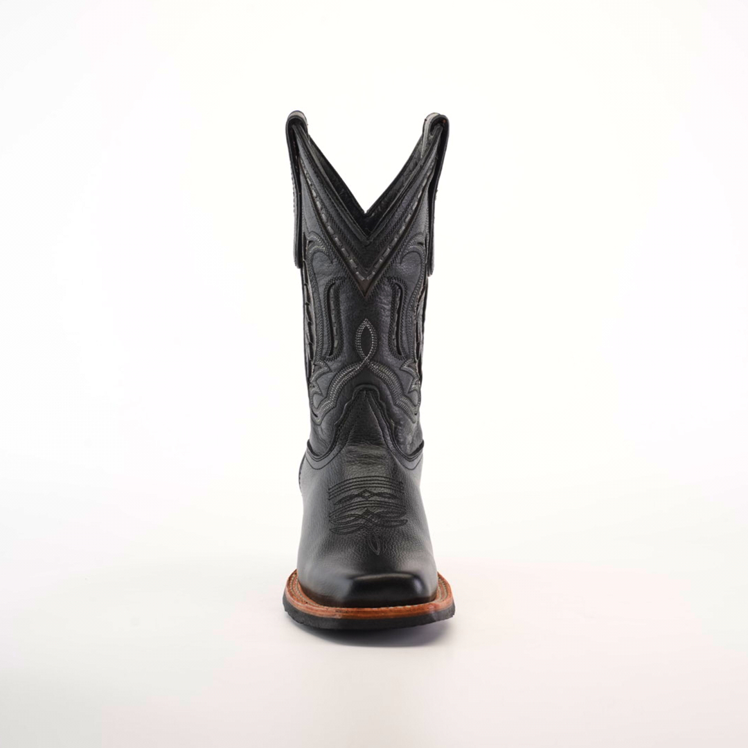 A single black cowboy boot, crafted from premium leather with intricate stitching and a pointed toe, features a Barcelona Black Slip Resistant Sole, captured from the front against a plain white background.