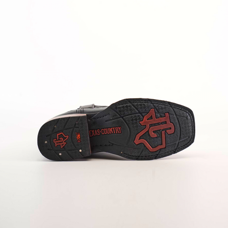 The image highlights the Barcelona Black Slip Resistant Sole of a black cowboy boot with red accents, featuring TEXAS COUNTRY and a large stylized logo. Crafted from premium leather, this boot is set against a plain white background.