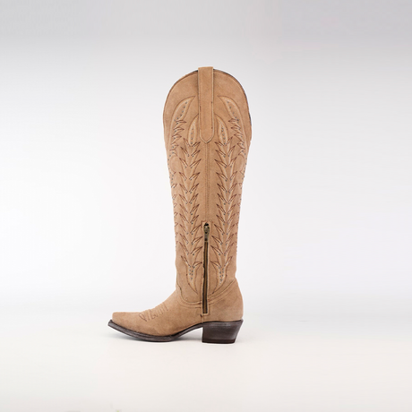 A Madona Sand Suede Tall Shaft cowboy boot with intricate embroidery and a side zipper stands against a white background. This handcrafted snip-toe boot exudes elegance with its slightly pointed toe and chunky heel.