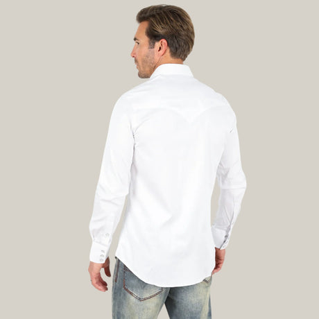 A man with light brown hair faces away from the camera, wearing a white Men’s Single Pocket Logo Modern Fit Stretch Dress Shirt - White - CTL9259 and faded jeans. The background is a solid light beige color.