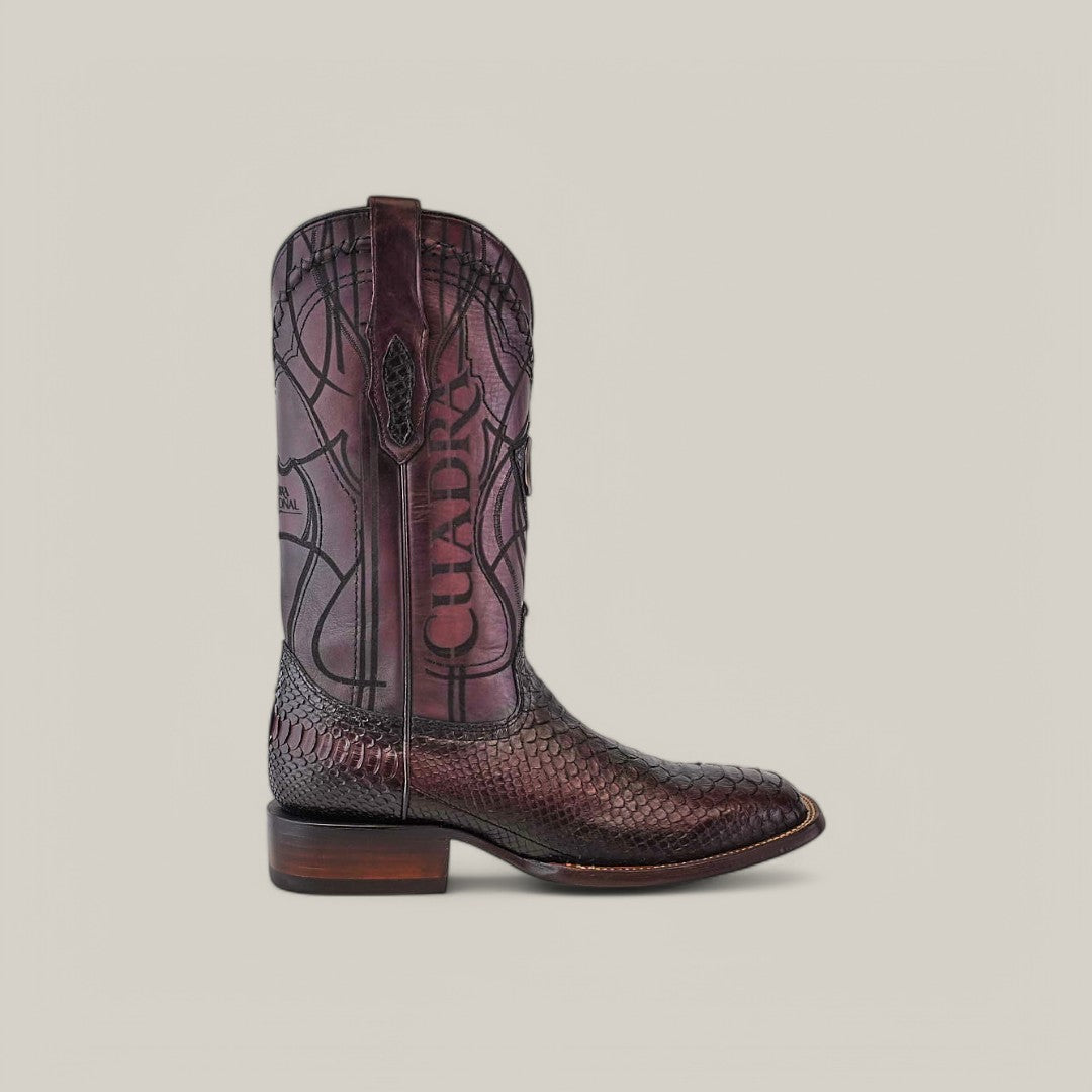 The Lisboa Cherry Python Embroidery & Laser & Woven cowboy boot features a rich brown leather with a striking snakeskin pattern and decorative stitching. Cuadra is embossed on the side, complemented by a square toe and low stacked heel, combining style and artistry.