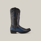 The Lisboa Blue Python Laser & Woven boot (CU736) features a black and blue textured python leather with an intricate shaft design, CHURCHILL pull strap, narrow square toe, and black heel, displayed on a beige background.