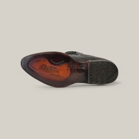 The image displays the sole of a Black Deer Laser & Embroidery - Round Toe - CU682 shoe made from black deer leather. It features Cuadra Tradicional marking, visible stitching, tread patterns, intricate laser-engraved details, and a slightly worn look against a plain background.