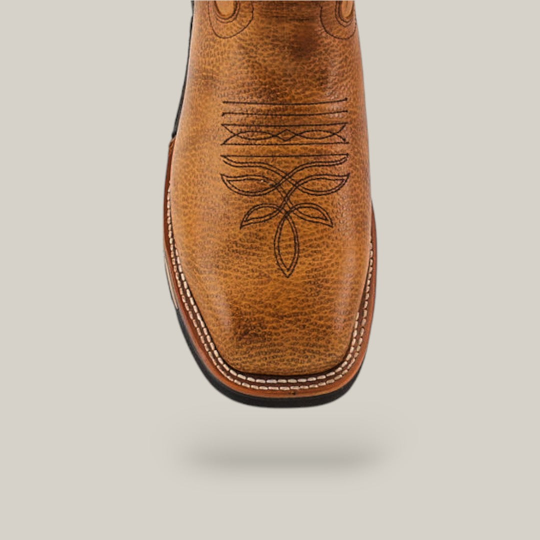 A close-up of the Taurus Honey Soft Toe - E6189, a tan cowboy boot with decorative stitching on the toe and a textured leather finish. It features a square toe shape with white edge stitching, exuding durability against a plain light gray background.