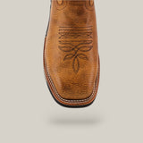 A close-up of the Taurus Honey Soft Toe - E6189, a tan cowboy boot with decorative stitching on the toe and a textured leather finish. It features a square toe shape with white edge stitching, exuding durability against a plain light gray background.