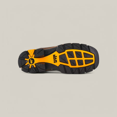 The Amazonas Dark Brown Soft Toe - E6256 shoe features a Texas Country Work Boots-inspired black and orange sole with large grooves and geometric shapes for traction. A yellow stylized sun with EE stands out near the heel against a beige background.