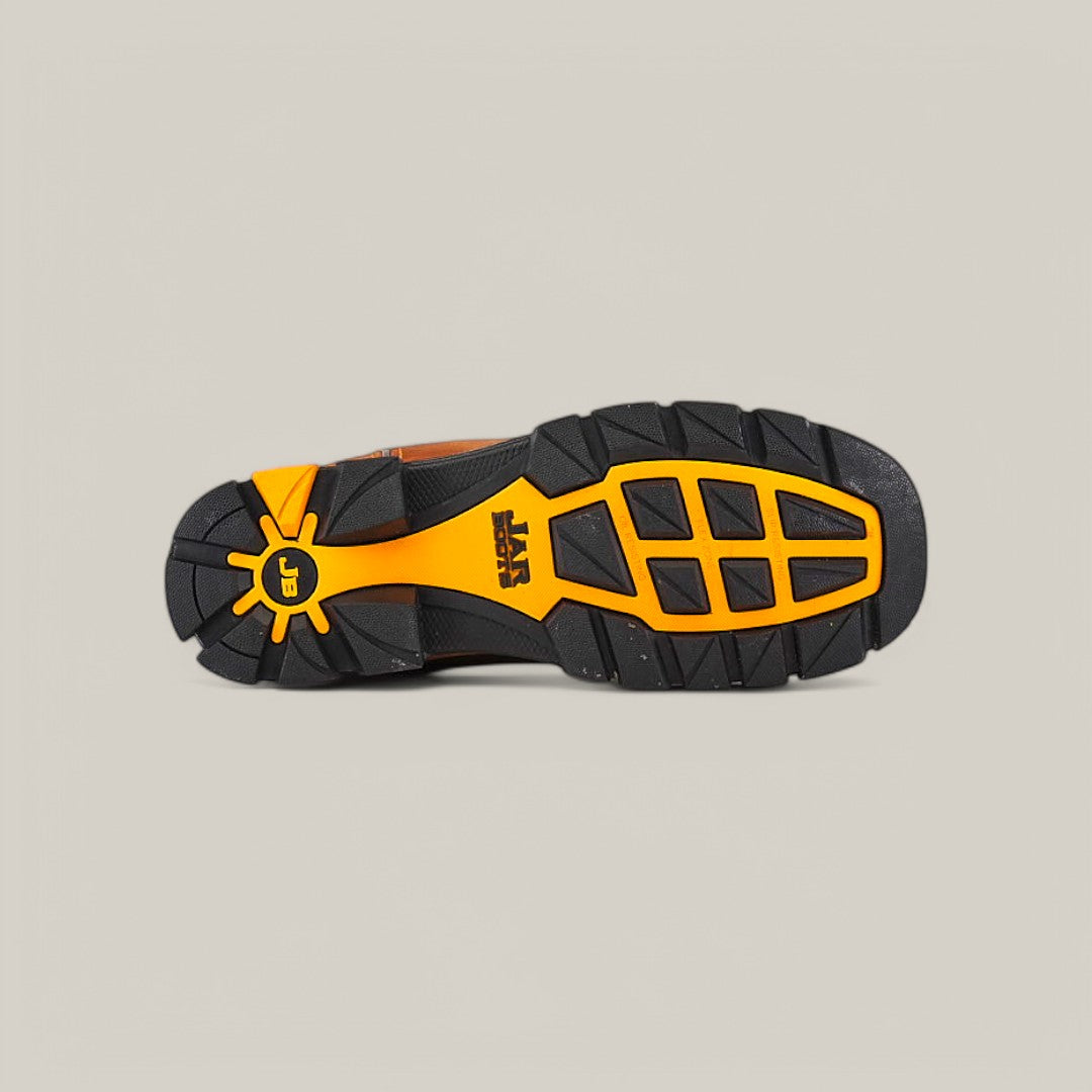 The image showcases the sole of the Amazonas Honey Composite Toe - E6259, emphasizing its durability with large black rubber lugs and orange accents. A yellow sunburst logo appears on the heel, CAT is prominently displayed, and all is set against a plain gray background.