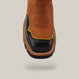 Close-up of the Crazy Honey Composite Toe - E6296, a brown leather Texas Country Work Boot with black and yellow accents on the toe. It features intricate stitching patterns and is known for its durability, centered against a plain light background.