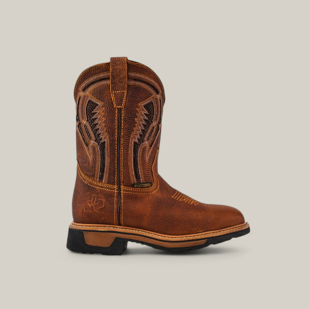 The Floter Honey Soft Toe - E6987 is a brown leather cowboy boot with intricate stitching and embroidery, rugged Texas charm, a textured dark sole, sturdy heel, and easy-wear loop. It combines decorative patterns and curved details in durable footwear.