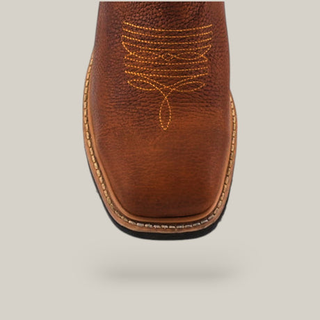 Close-up of the toe of a Floter Honey Composite Toe - E6987, showcasing its intricate yellow stitching on brown leather. This robust boot features a square toe design with visible sole stitching, set against a plain light gray background.