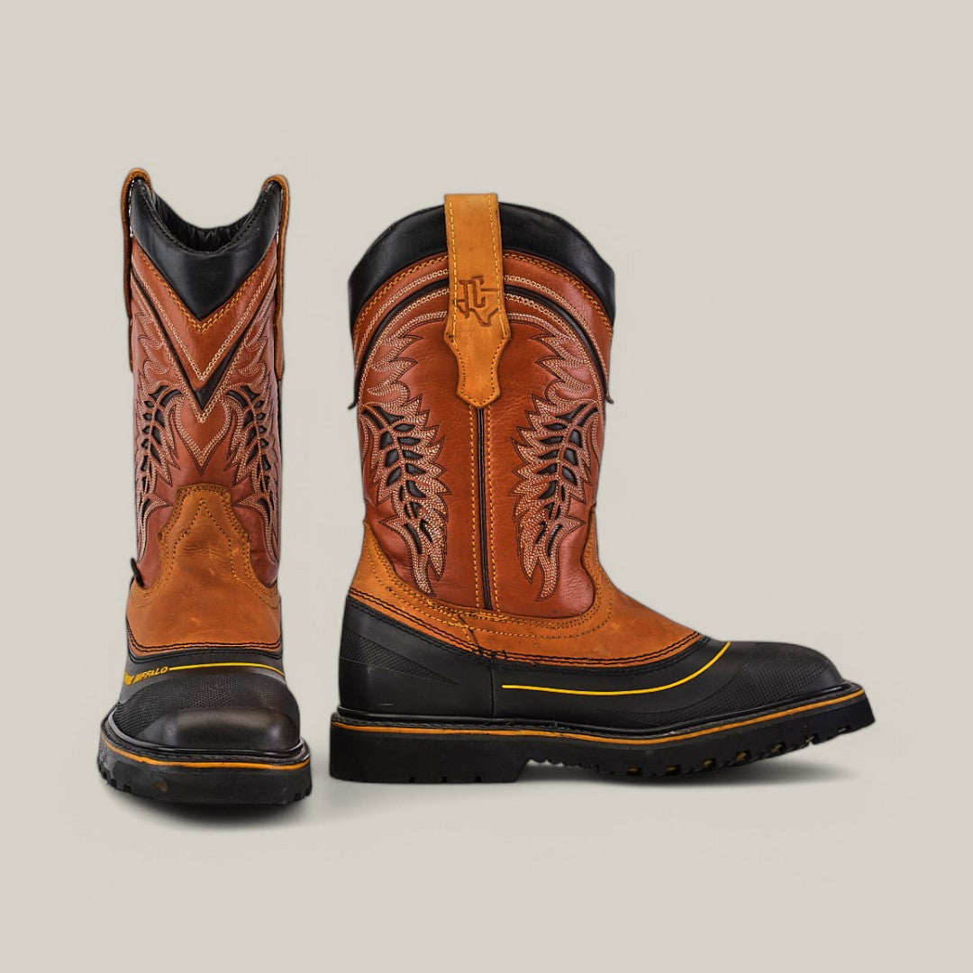 The Crazy Honey Soft Toe - E6048 is a rugged pair of Texas Country Work Boots in brown and black, with intricate leaf patterns on the shaft. Built for durability, these boots feature a split and textured sole, leather pull straps, and mixed leather design. Ideal for tackling tough terrain.