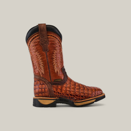 The Alligator Print Cogñac Composite Toe - E6022, a single brown leather cowboy boot with intricate stitching and a crocodile-like design on the lower half, showcases Texas Country Work Boot craftsmanship with a dark sole, heel, and decorative loops against a plain background.