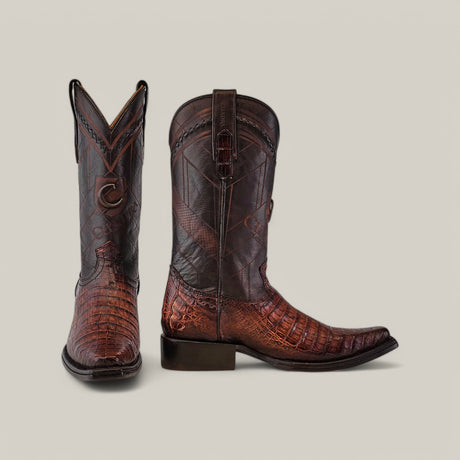 The Arauco Chocolate Caiman Laser & Woven boots (CU551) feature a narrow square toe and are crafted from dark brown and reddish-brown Caiman leather with a crocodile texture. The left boot stands upright, while the right boot rests on its side against a neutral background.