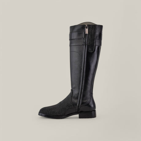 The Black Stingray Zipper - Round Toe - FC637 is an elegant riding boot crafted from black leather with a side zipper. The lower section features textured stingray leather, while the upper remains smooth, all set against a light gray backdrop.