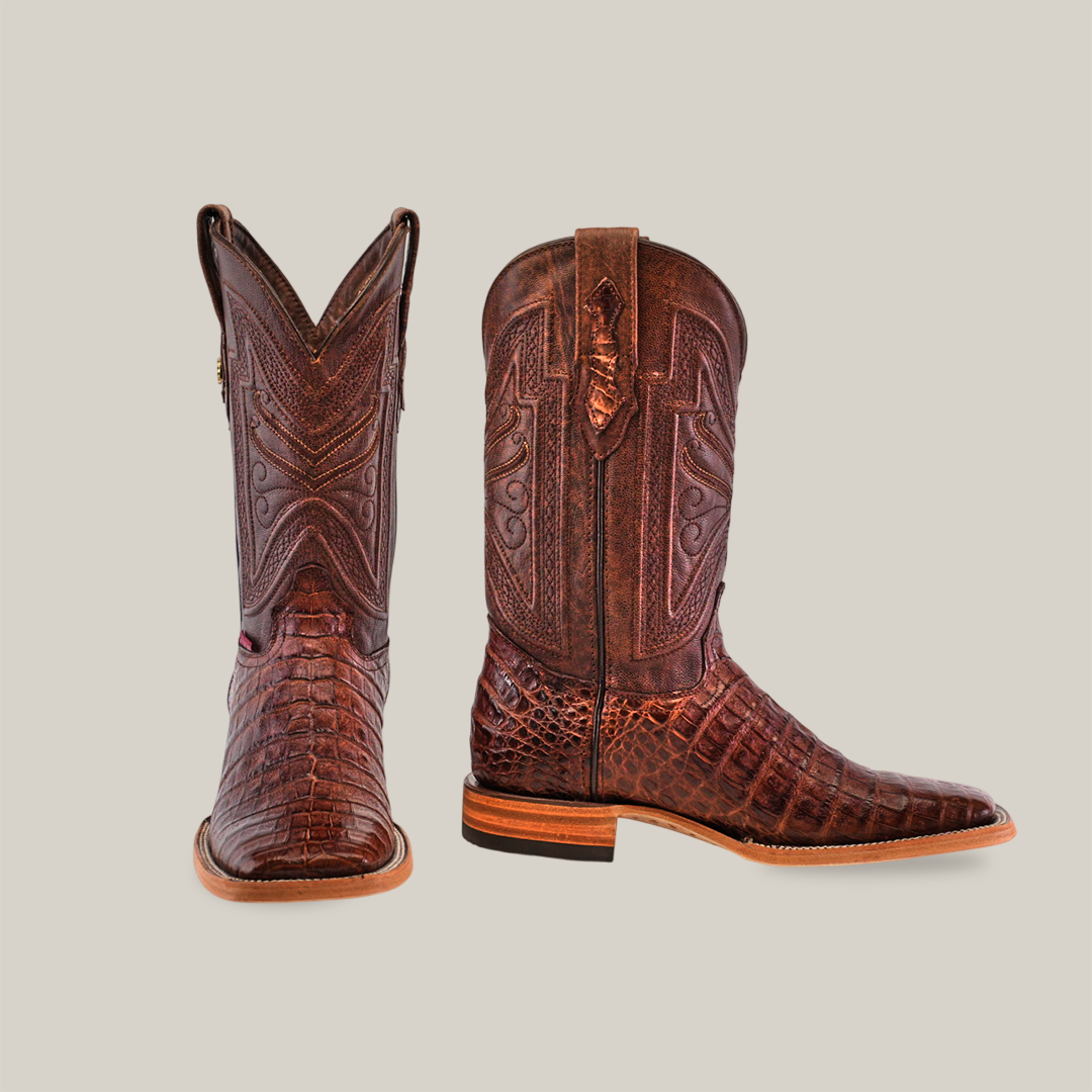 The Exotic Caiman Belly - Brown - Square Toe boots, made from genuine caiman leather, boast intricate stitching and a textured pattern. One boot is shown front-facing while the other is side-faced against a plain light background.