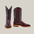 A pair of Exotic Caiman Belly boots in Black Cherry with a square toe features intricate front and side stitching. One boot shows off the textured surface and wooden heels against a plain background, highlighting the classic elegance of cowboy footwear.