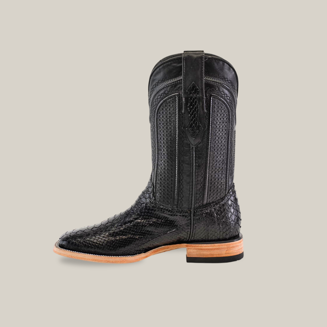 The Exotic Python - Black - Square Toe boot, made from exquisite textured python leather with detailed stitching and a wooden sole, is angled to the left against a plain beige backdrop.