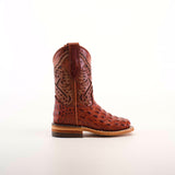 The Caiman Hornback Print Cogñac Square Toe boot, featuring a textured reptile-like pattern and intricate stitching, graces a wooden surface. Its premium brown leather finish stands out against the plain light background, highlighting its quality and craftsmanship.