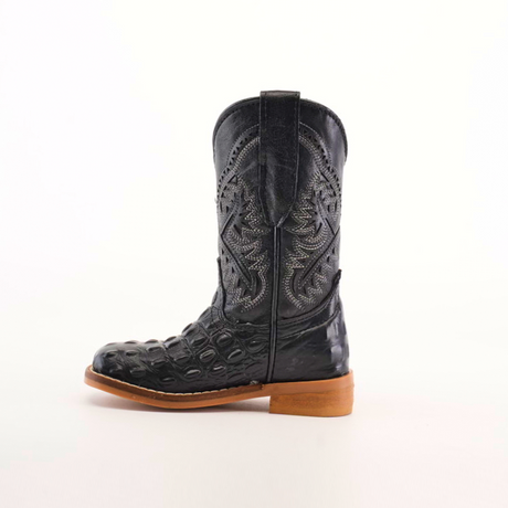 A single handcrafted Caiman Hornback Print Black Square Toe cowboy boot sits against a plain white background. Made from premium leather, it boasts intricate patterns, textured designs, a high shaft, and is complemented by a sturdy wooden heel.