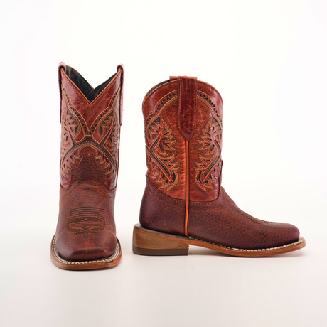 The Cheyenne Shedron Square Toe boots are crafted from genuine brown cowhide leather, featuring intricate embroidery on the shafts. They have a rounded toe and a stacked heel, elegantly displayed against a plain white background.