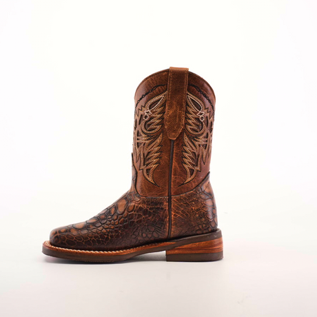 The Loggerhead Turtle Print brown Rodeo Toe boot, made from premium cowhide leather, showcases intricate stitching on the upper shaft with a textured foot design. It features a slightly raised heel and pull strap, standing upright against a plain white background.