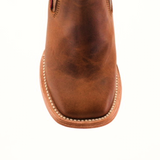 Close-up of the Avejentado Honey Square Toe ankle boot in genuine brown leather with a square toe and white stitching around the edge, isolated on a white background.